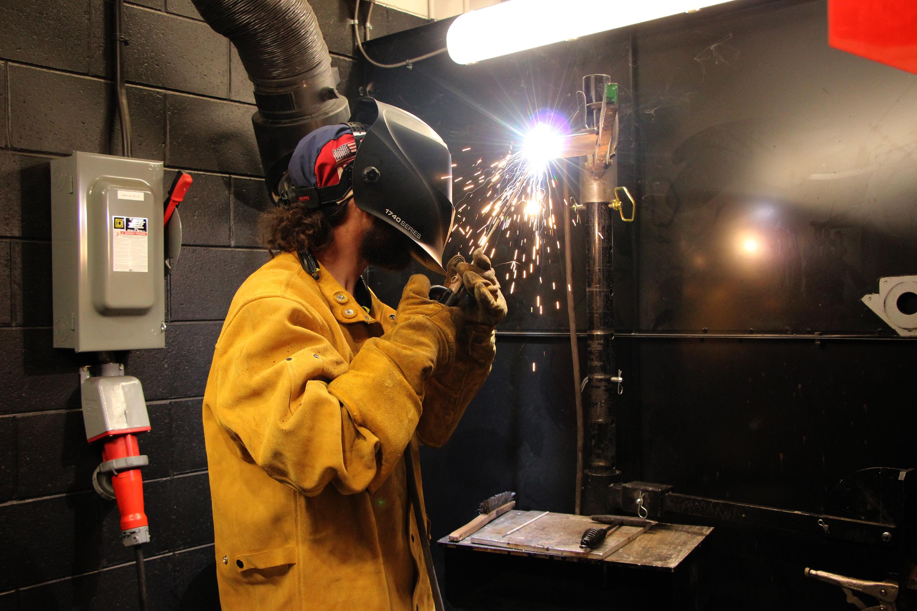 A student welds two pieces of metal together